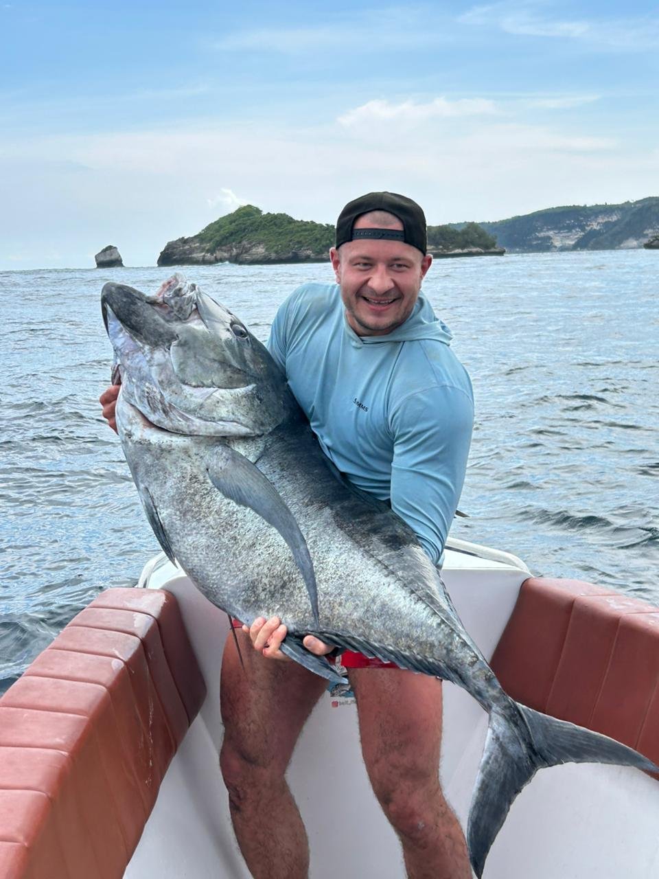 Angler holding giant amberjack during fishing trip in Nusa Penida