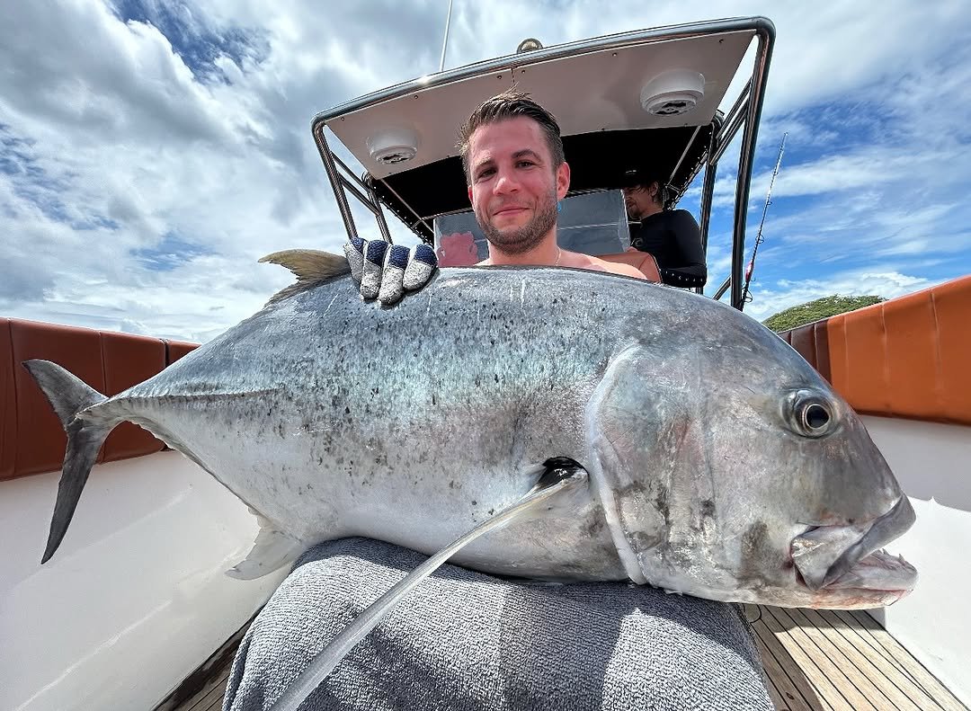 Client with large Giant Trevally caught in Bali waters