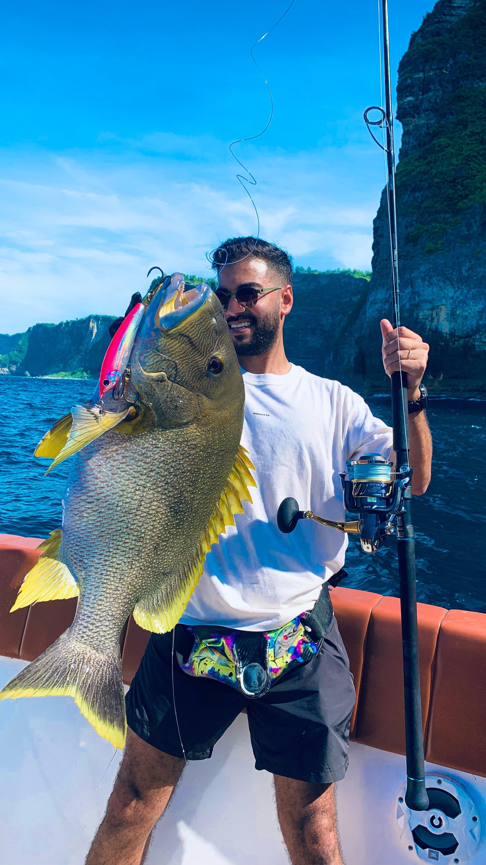 Angler holding a colorful maori fish of Nusa Penida Bali during fishing charter trip